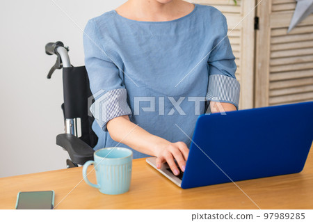 A young woman using a laptop in a wheelchair Image of a diverse society A young woman using a laptop in a wheelchair Image of a diverse society 97989285