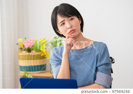 A young woman using a laptop in a wheelchair Image of a diverse society A young woman using a laptop in a wheelchair Image of a diverse society 97989288