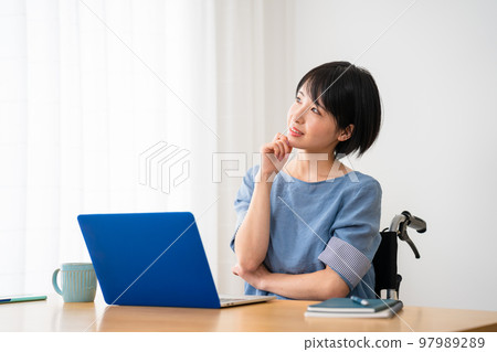 A young woman using a laptop in a wheelchair Image of a diverse society A young woman using a laptop in a wheelchair Image of a diverse society 97989289