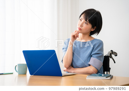 A young woman using a laptop in a wheelchair Image of a diverse society A young woman using a laptop in a wheelchair Image of a diverse society 97989291