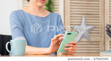 坐在輪椅上操作智能手機的年輕女性 多元社會的形象 坐在輪椅上操作智能手機的年輕女性 多元社會的形象 97989300