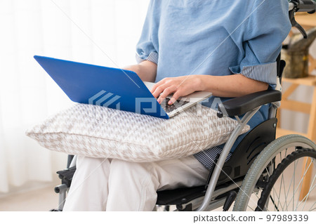 A young woman using a laptop in a wheelchair Image of a diverse society A young woman using a laptop in a wheelchair Image of a diverse society 97989339