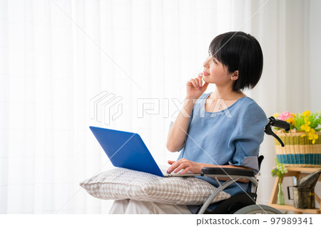 A young woman using a laptop in a wheelchair Image of a diverse society A young woman using a laptop in a wheelchair Image of a diverse society 97989341