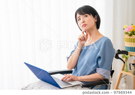 A young woman using a laptop in a wheelchair Image of a diverse society A young woman using a laptop in a wheelchair Image of a diverse society 97989344