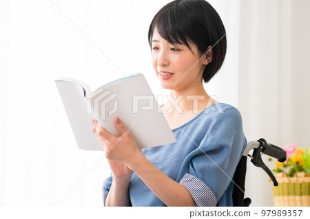 坐在輪椅上操作智能手機的年輕女性 多元社會的形象 坐在輪椅上操作智能手機的年輕女性 多元社會的形象 97989357