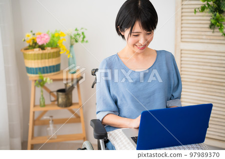 A young woman using a laptop in a wheelchair Image of a diverse society A young woman using a laptop in a wheelchair Image of a diverse society 97989370