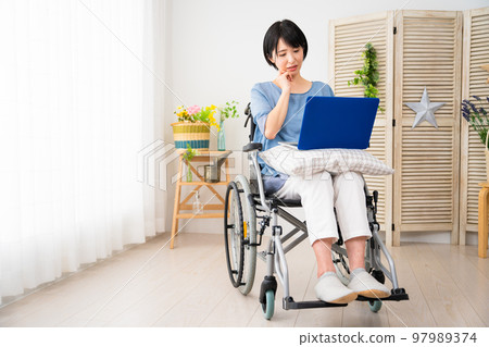 坐在輪椅上使用筆記本電腦的年輕女性 多元化社會的形象 坐在輪椅上使用筆記本電腦的年輕女性 多元化社會的形象 97989374