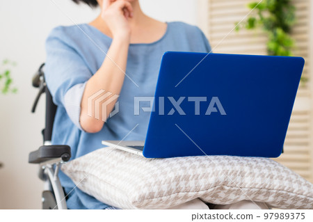 A young woman using a laptop in a wheelchair Image of a diverse society A young woman using a laptop in a wheelchair Image of a diverse society 97989375