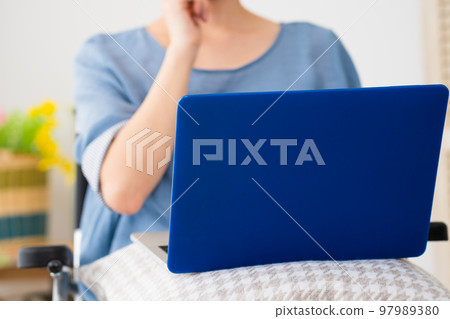坐在輪椅上使用筆記本電腦的年輕女性 多元化社會的形象 坐在輪椅上使用筆記本電腦的年輕女性 多元化社會的形象 97989380