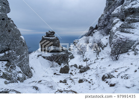Rocks on Mount Alenga near Southern Demerdzhi in snow and ice in spring. Crimea 97991435