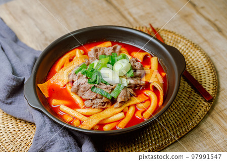 黑盤上放著辣味韓國菜 Tteokbokki,配有牛肉、蔬菜和魚餅 黑盤上放著辣味韓國菜 Tteokbokki,配有牛肉、蔬菜和魚餅 97991547
