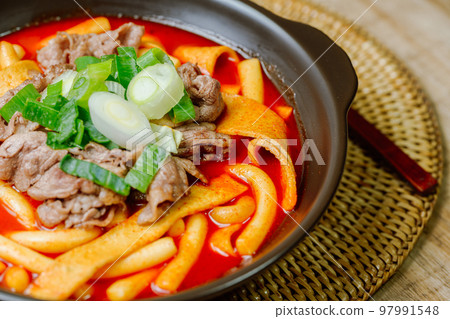 黑盤上放著辣味韓國菜 Tteokbokki,配有牛肉、蔬菜和魚餅 黑盤上放著辣味韓國菜 Tteokbokki,配有牛肉、蔬菜和魚餅 97991548