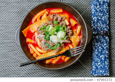 黑盤上放著辣味韓國菜 Tteokbokki,配有牛肉、蔬菜和魚餅 黑盤上放著辣味韓國菜 Tteokbokki,配有牛肉、蔬菜和魚餅 97991572