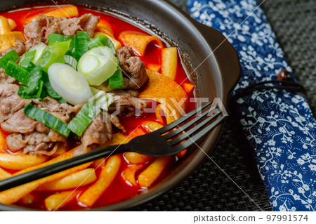 Spicy Korean food Tteokbokki with beef, vegetables and fish cake served on a black plate Spicy Korean food Tteokbokki with beef, vegetables and fish cake served on a black plate 97991574