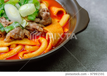 黑盤上放著辣味韓國菜 Tteokbokki,配有牛肉、蔬菜和魚餅 黑盤上放著辣味韓國菜 Tteokbokki,配有牛肉、蔬菜和魚餅 97991591