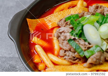 黑盤上放著辣味韓國菜 Tteokbokki,配有牛肉、蔬菜和魚餅 黑盤上放著辣味韓國菜 Tteokbokki,配有牛肉、蔬菜和魚餅 97991592