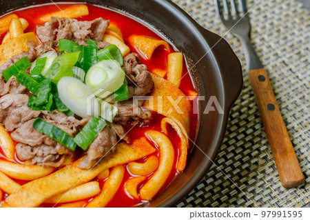 黑盤上放著辣味韓國菜 Tteokbokki,配有牛肉、蔬菜和魚餅 黑盤上放著辣味韓國菜 Tteokbokki,配有牛肉、蔬菜和魚餅 97991595
