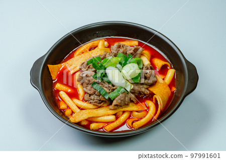 黑盤上放著辣味韓國菜 Tteokbokki，配有牛肉、蔬菜和魚餅 97991601