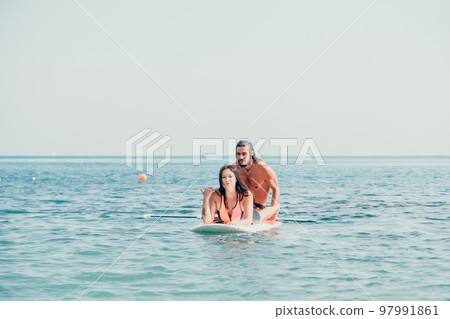 Sea woman and man on sup. Silhouette of happy young woman and man, surfing on SUP board, confident paddling through water surface. Idyllic sunset. Active lifestyle at sea or river. Sea woman and man on sup. Silhouette of happy young woman and man, surfing on SUP board, confident paddling through water surface. Idyllic sunset. Active lifestyle at sea or river. 97991861