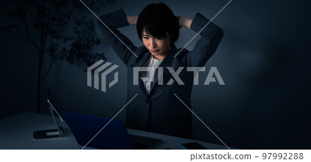 Young business woman holding her head in the office Overtime image Young business woman holding her head in the office Overtime image 97992288