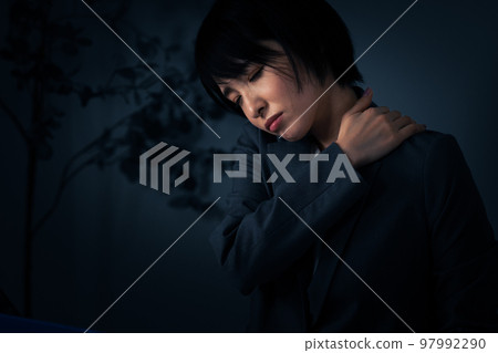 年輕的女商人在辦公室加班時揉著肩膀 年輕的女商人在辦公室加班時揉著肩膀 97992290