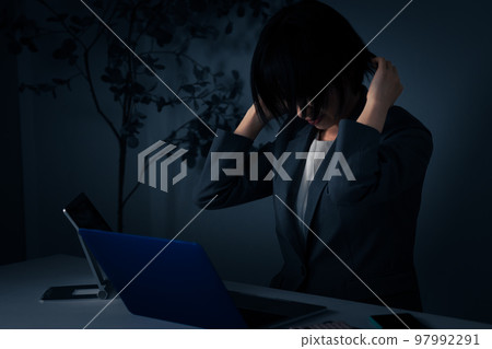 年輕女商人在辦公室裡抱著頭加班圖片 97992291