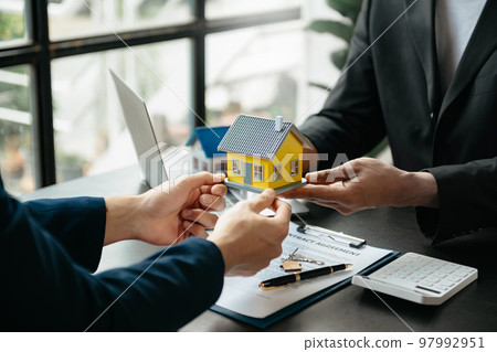 Considering buying a home, investing in real estate. Broker signs a sales agreement. agent, lease agreement, successful deal . 97992951