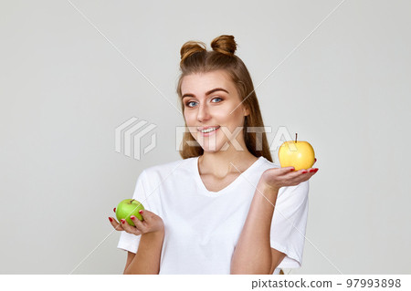 smiling woman holding green and yellow apples 97993898