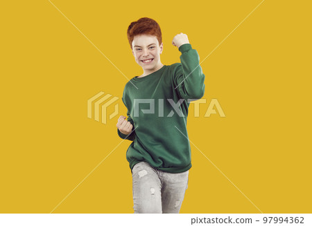 Happy standing isolated on orange background, celebrating success and doing yes gesture 97994362