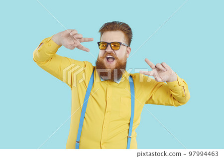 Funny bearded Caucasian man performs dance working as presenter or showman stands in studio 97994463