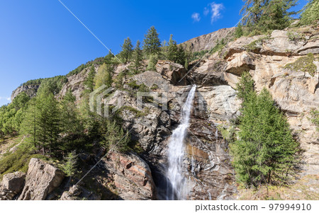 Lillaz waterfall on granite ledges of rock with green pine trees in Gran Paradiso National Park Lillaz waterfall on granite ledges of rock with green pine trees in Gran Paradiso National Park 97994910