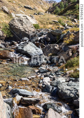 Small pond of clear water with pebbles, sand and cobblestones between rapids of mountain gorge Small pond of clear water with pebbles, sand and cobblestones between rapids of mountain gorge 97994912
