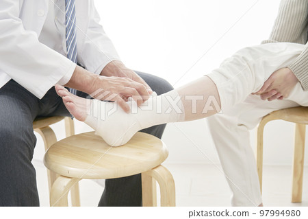 A doctor bandaging his leg Faceless 97994980