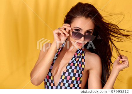 Close up Image of beautiful young sexy slim brunette woman posing on yellow background. Swimsuit swimwear or bikini model 97995212