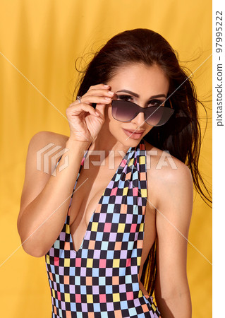 Close up Image of beautiful young sexy slim brunette woman posing on yellow background. Swimsuit swimwear or bikini model 97995222