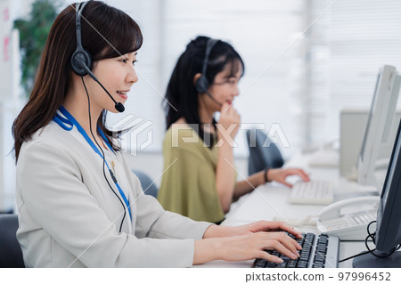 在呼叫中心為客戶服務的女士 在呼叫中心為客戶服務的女士 97996452