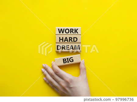 Work and dream symbol. Wooden blocks with words Work Hard Dream Big. Beautiful yellow background. Businessman hand. Business and Work Hard Dream Big concept. Copy space. 97996736