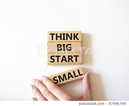 Think big start small symbol. Concept words Think big start small on wooden blocks. Beautiful white background. Businessman hand. Business and Think big start small concept. Copy space Think big start small symbol. Concept words Think big start small on wooden blocks. Beautiful white background. Businessman hand. Business and Think big start small concept. Copy space 97996740