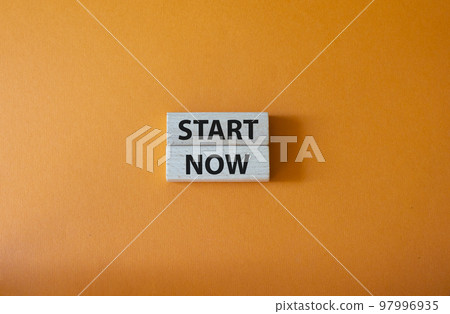 Start now symbol. Wooden blocks with words Start now. Beautiful orange background. Business and Start now concept. Copy space. 97996935