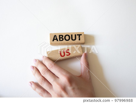 About us symbol. Wooden blocks with words About us. Beautiful white background. Businessman hand. Business and About us concept. Copy space. 97996988