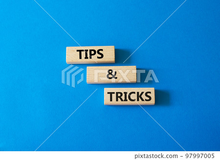 Tips and tricks symbol. Wooden blocks with words Tips and tricks. Beautiful blue background. Business concept and Tips and tricks. Copy space. 97997005