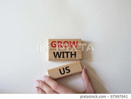 Grow with us symbol. Wooden blocks with words Grow with us. Beautiful white background. Businessman hand. Business and Grow with us concept. Copy space. 97997041