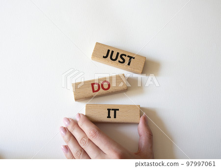 Just do it symbol. Wooden blocks with words Just do it. Beautiful white background. Businessman hand. Business and Just do it concept. Copy space. 97997061
