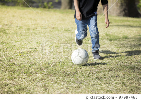 Boys feet practicing soccer in the park 97997463