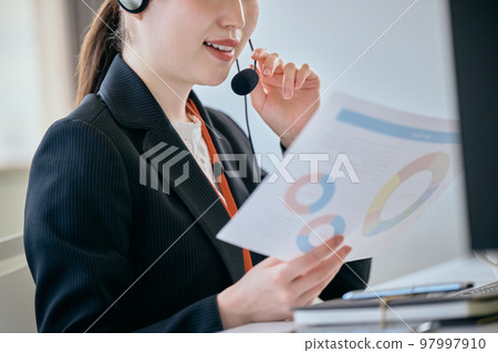 Young woman answering the phone in the office 97997910
