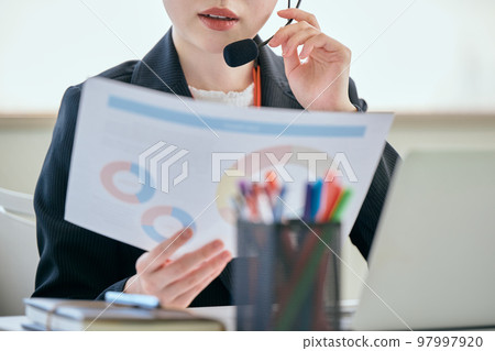 Young woman answering the phone in the office Young woman answering the phone in the office 97997920