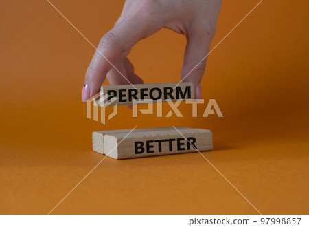 Perform better symbol. Wooden blocks with words Perform better. Businessman hand. Beautiful orange background. Business and Perform better concept. Copy space. Perform better symbol. Wooden blocks with words Perform better. Businessman hand. Beautiful orange background. Business and Perform better concept. Copy space. 97998857