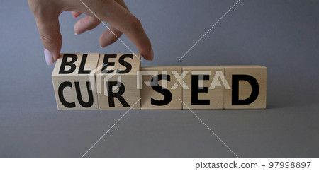 Blessed vs Cursed word symbol. Businessman Hand turns cubes with word Cursed and changes it to word Blessed. Beautiful grey background. Religious and Blessed vs Cursed concept Blessed vs Cursed word symbol. Businessman Hand turns cubes with word Cursed and changes it to word Blessed. Beautiful grey background. Religious and Blessed vs Cursed concept 97998897