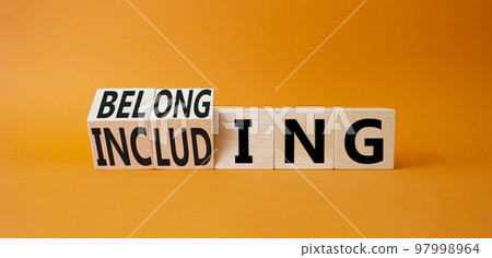 Belonging and Including symbol. Turned cubes with words Belonging and Including. Beautiful oarnge background. Business, psychological and Belonging and Including concept. Copy space 97998964