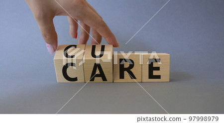 Cure and Care symbol. Businessman hand turnes wooden cubes and changes words Care to Cure. Beautiful grey background. Business and cure and care concept. Copy space Cure and Care symbol. Businessman hand turnes wooden cubes and changes words Care to Cure. Beautiful grey background. Business and cure and care concept. Copy space 97998979